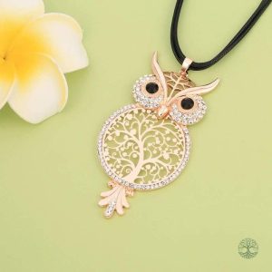 Bijou en or rose représentant un arbre de vie et une chouette